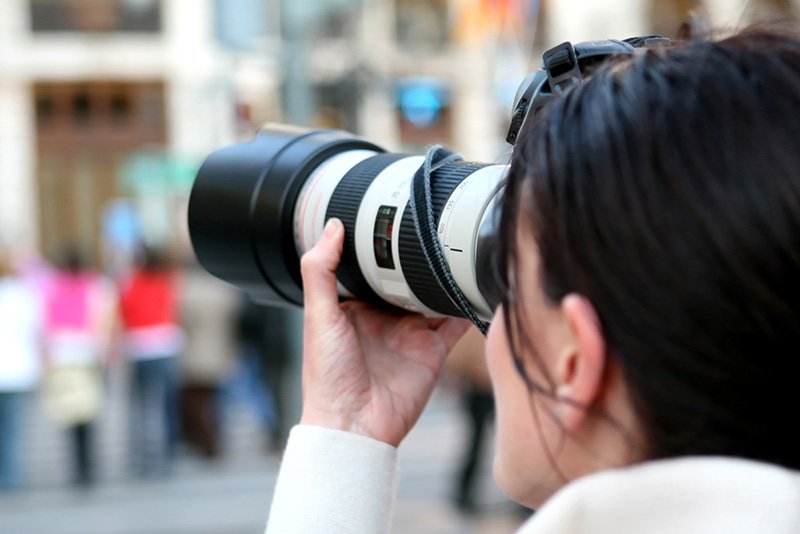 Photographer looking through a camera
